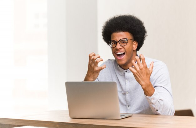 Jovem usando seu laptop com raiva e chateado