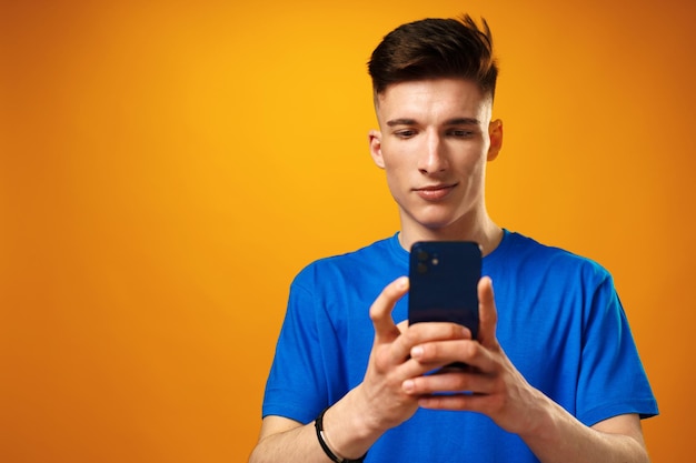 Jovem usando smartphone contra fundo amarelo