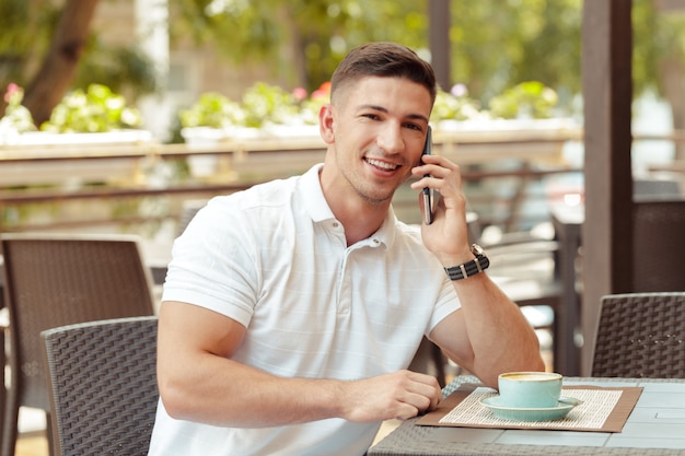 Jovem usando smartphone no café