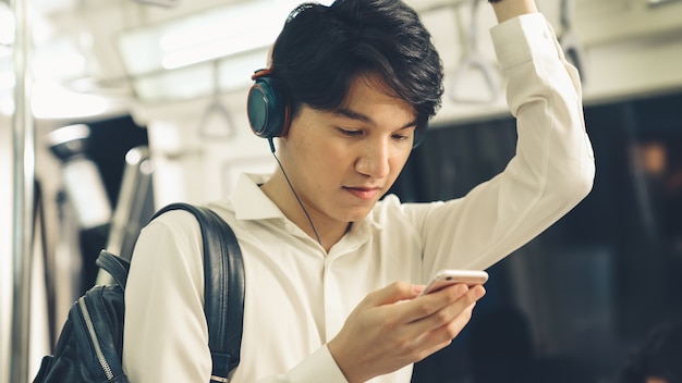 Jovem usando telefone celular em trem público