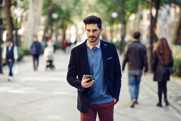 Jovem usando telefone celular enquanto está de pé na calçada