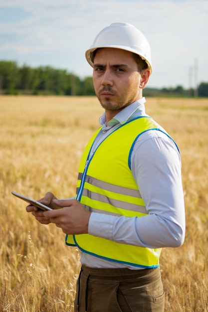 Foto jovem usando telefone celular enquanto está de pé no campo