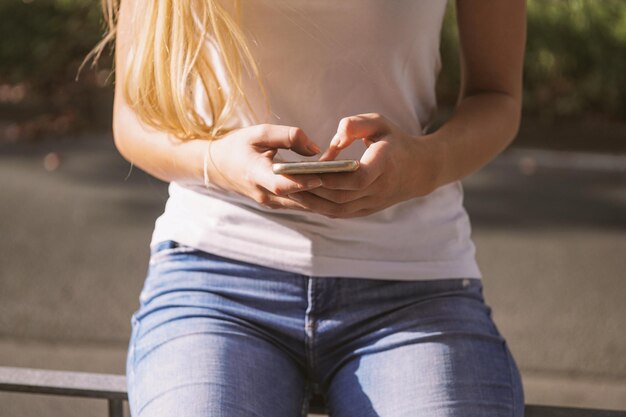 jovem usando um smartphone em um dia ensolarado na cidade