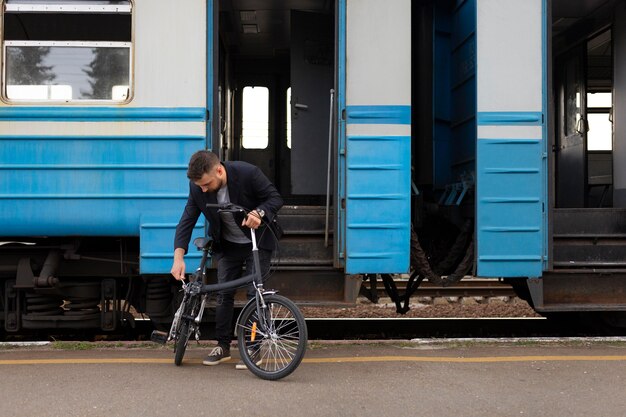 Foto jovem usando uma bicicleta dobrável enquanto viaja de trem