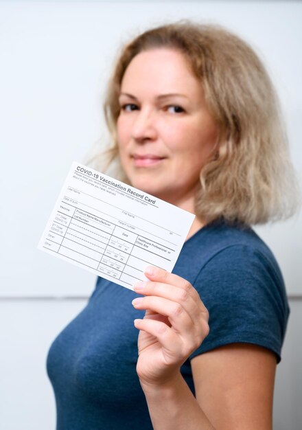 Jovem vacinada mostrando o Cartão de Registro de Vacinação COVID19