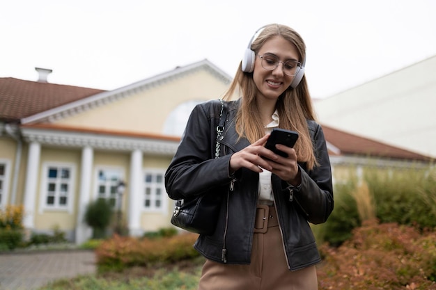 Jovem vai trabalhar ouvindo música em fones de ouvido via celular