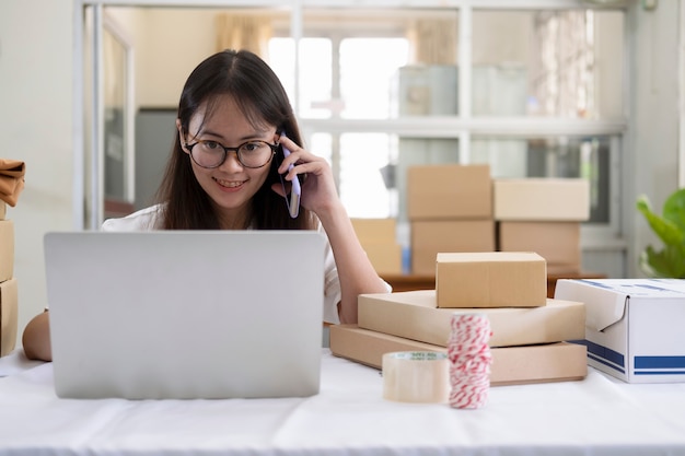 Foto jovem vendedor online falando no telefone para receber e verificar pedidos dos clientes