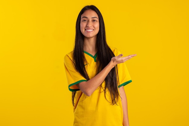 Jovem vestindo a camisa oficial do time de futebol brasileiro na Copa do Catar 2022 em foto de estúdio fã brasileiro