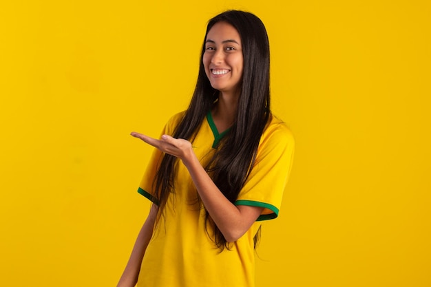 Jovem vestindo a camisa oficial do time de futebol brasileiro na Copa do Catar 2022 em foto de estúdio fã brasileiro