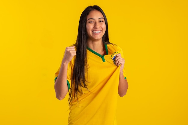 Jovem vestindo a camisa oficial do time de futebol brasileiro na copa do catar 2022 em foto de estúdio fã brasileiro