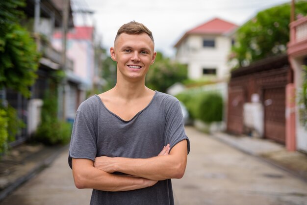 Jovem vestindo camisa cinza na rua ao ar livre