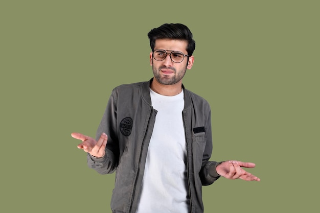 jovem vestindo jaqueta e óculos louco, confuso, se sentindo incomodado modelo indiano do paquistanês