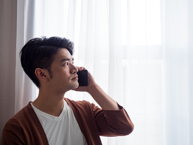 Jovem vestindo roupas casuais e falando no celular