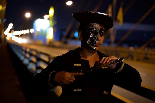 Jovem vestindo traje de pirata de pé na ponte à noite
