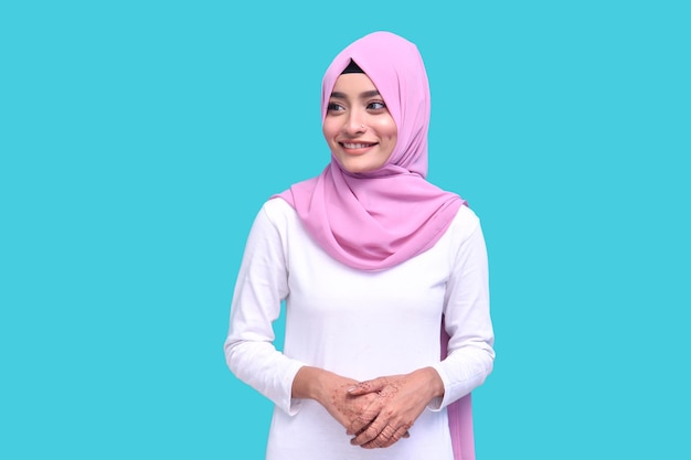 jovem vestindo um hijab rosa com camisa branca sorrindo sobre fundo azul modelo indiano do paquistanês