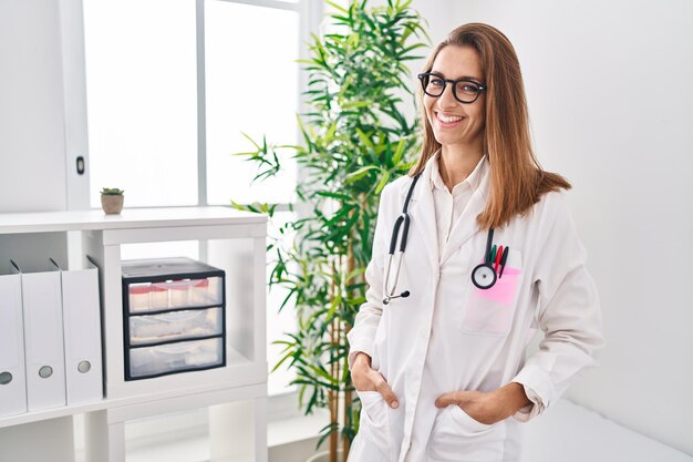 Foto jovem vestindo uniforme médico em pé na clínica