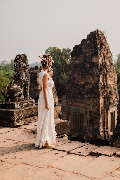 Jovem vestindo vestido de túnica branca em antigas ruínas Khmer Angkor Wat