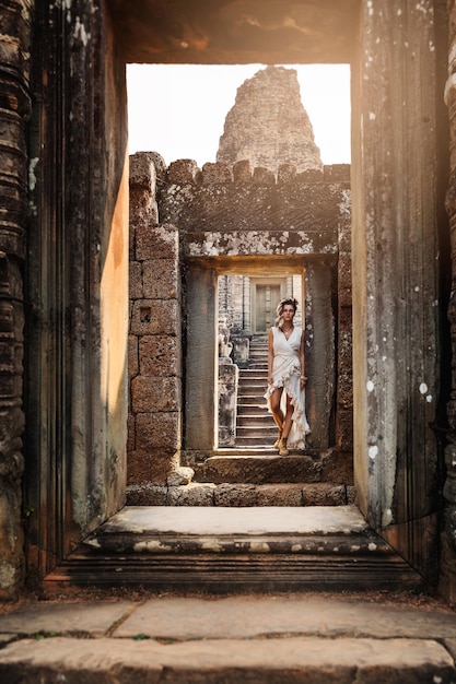 Jovem vestindo vestido de túnica branca em antigas ruínas Khmer Angkor Wat