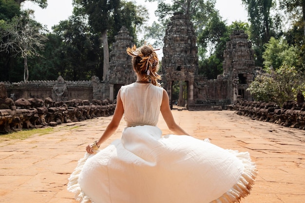 Jovem vestindo vestido de túnica branca em antigas ruínas Khmer Angkor Wat