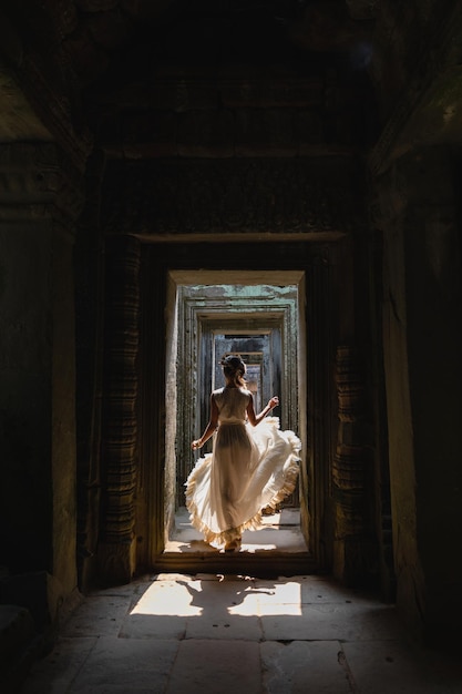 Jovem vestindo vestido de túnica branca em antigas ruínas khmer angkor wat