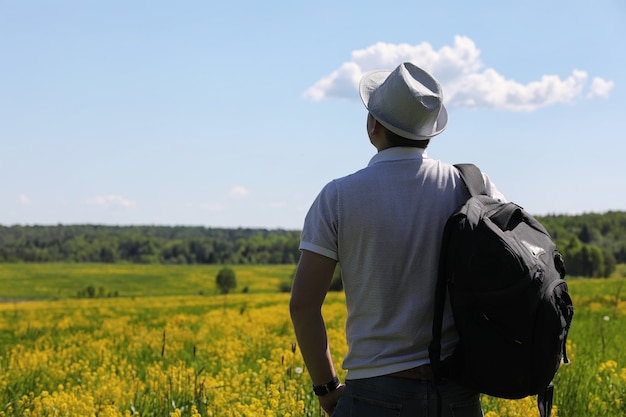 Jovem viaja com uma mochila em um dia de verão ao ar livre