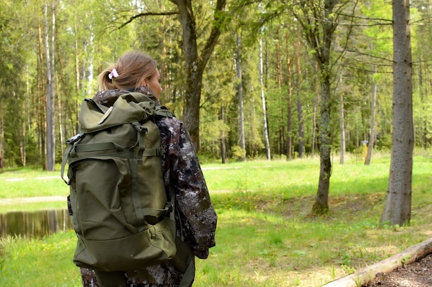 jovem viajante com fundo de mochila ao ar livre. Acampamento de férias na floresta