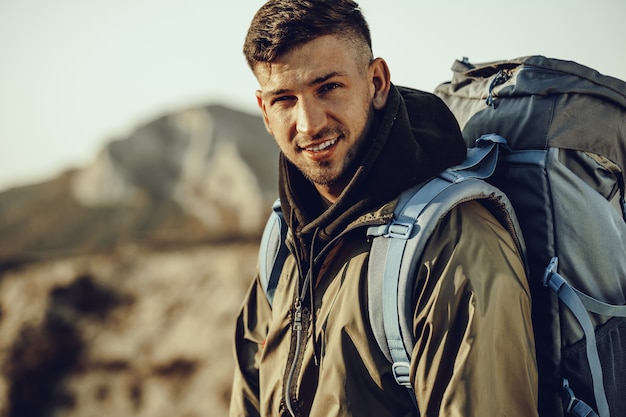 Jovem viajante com mochila grande, caminhando nas montanhas