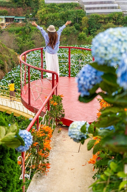 Jovem viajante desfrutando de um jardim de hortênsias em flor em Dalat Vietnã Conceito de estilo de vida de viagem