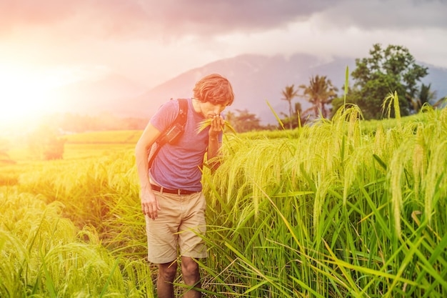 Jovem viajante em belos terraços de arroz jatiluwih no contexto de famosos vulcões em bali, indonésia com luz solar