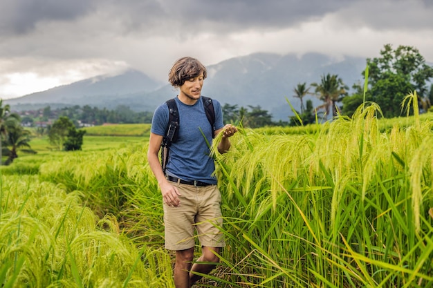 Jovem viajante em belos terraços de arroz Jatiluwih no contexto de famosos vulcões em Bali, Indonésia