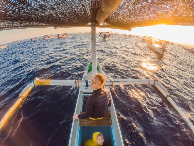 Foto jovem viajante encontra o amanhecer no mar em um barco