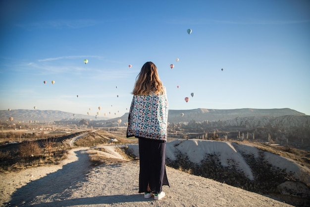 Jovem viajante feliz desfrutando de férias na Capadócia, Turquia Garota olha para os balões da Capadócia