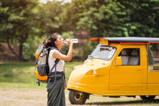 Jovem viajante feminino asiático é água potável