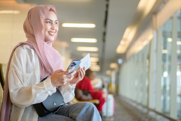 Jovem viajante muçulmana carregando malas no aeroporto internacional