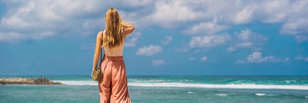 Jovem viajante na incrível Melasti Beach com água turquesa, Bali Island Indonésia BANNER, FORMATO LONGO