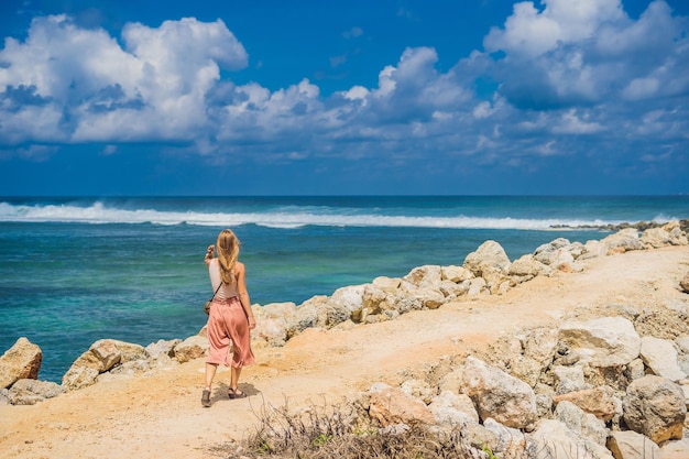 Jovem viajante na incrível Melasti Beach com água turquesa, Bali Island Indonésia