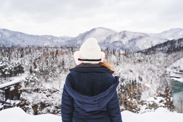 Jovem viajante olhando uma bela paisagem no inverno