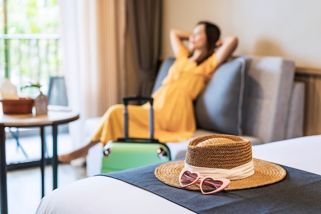 Foto jovem viajante sentada e relaxando em um quarto de hotel durante as férias de verão