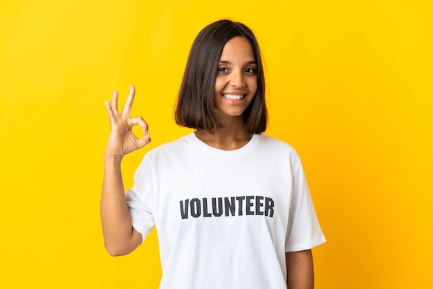 Jovem voluntária amarela mostrando sinal de ok com os dedos
