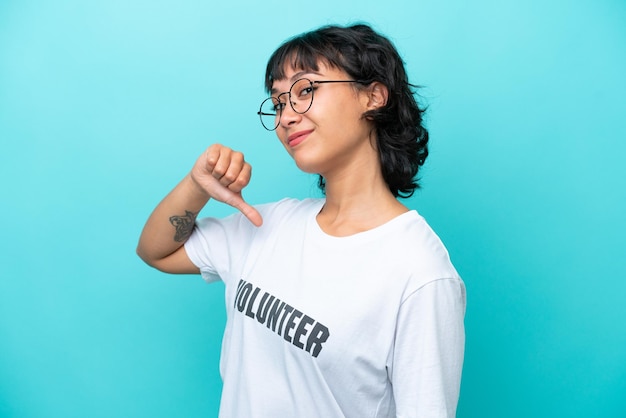 Jovem voluntária argentina isolada em fundo azul orgulhosa e satisfeita