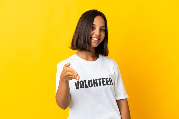 Jovem voluntária em amarelo apertando as mãos para fechar um bom negócio