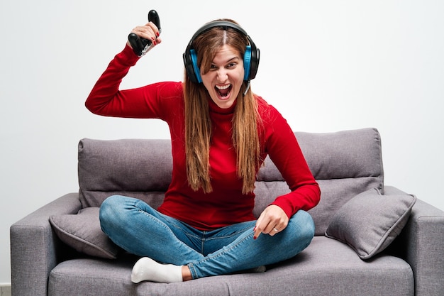 Jovem zangada jogando videogame em casa