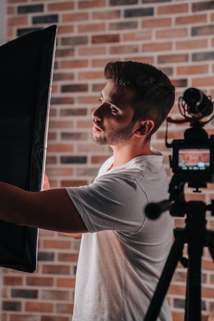 Foto joven de unos 20 años configurando su estudio de iluminación para transmitir en vivo