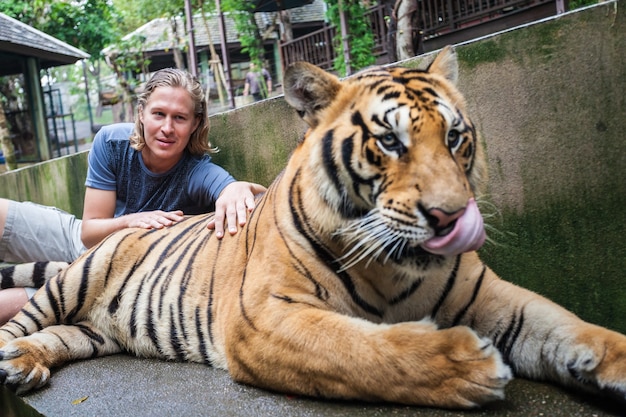 Joven abrazando a un gran tigre en Tailandia