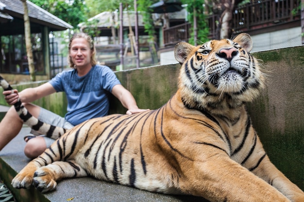 Joven abrazando a un gran tigre en Tailandia