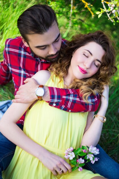 Joven abrazando a su novia en el jardín de verano