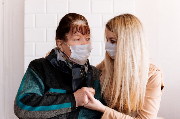 Joven y una abuela anciana con máscaras médicas, durante el período de cuarentena de la pandemia de coronavirus