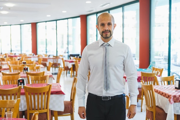 Joven administrador de restaurante parado dentro