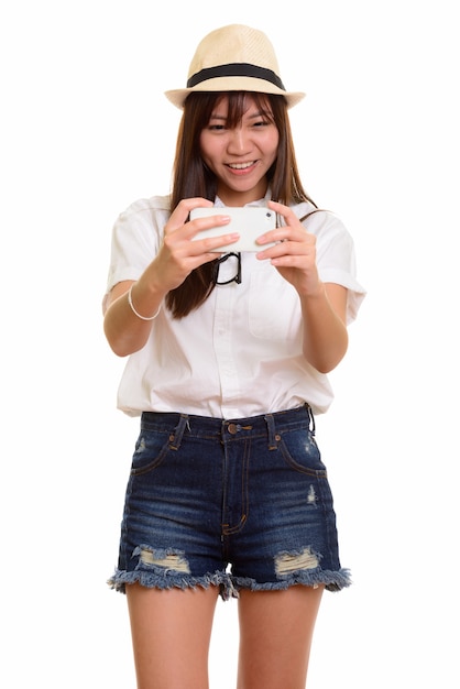 Joven adolescente asiática feliz sonriendo y tomando fotografías