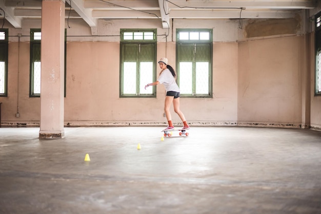 Joven adolescente asiática jugando patineta deporte urbano estilo de vida feliz y divertido con patineta